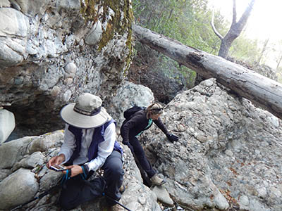 Photo of geographers inspecting boulders.