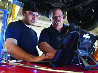 student and instructor working on a car