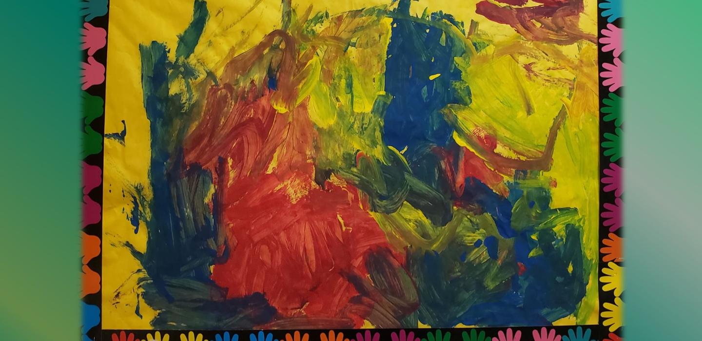 Painting with blue, red and green tempera paint in a yellow paper with handprint borders