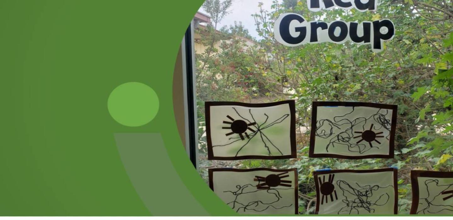 Spider web children project posted in a window with the words Red Group on the top