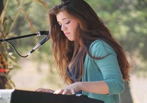 Marci Katznelson playing piano with microphone
