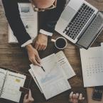 Business workers discussing over graphs on a desk.