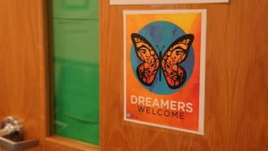 Sign on a door with a butterfly and the text "Dreamers Welcome"