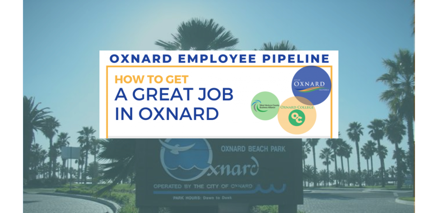 image of wooden Oxnard city sign at beach parking lot with palm trees in background