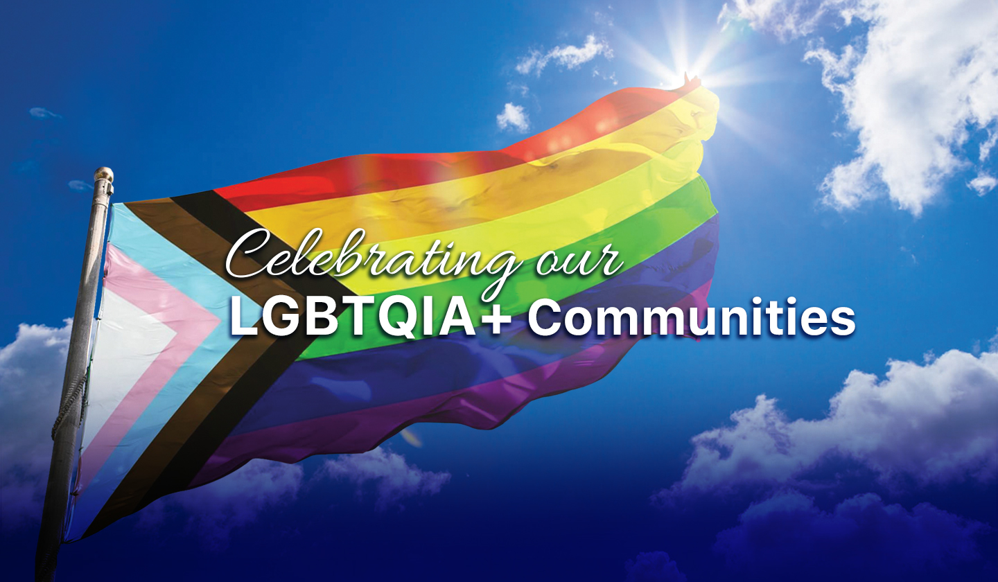 LGBTQIA+ Progress Flag waving in the sky. Text that reads: Celebrating our LGBTQIA+ Communities