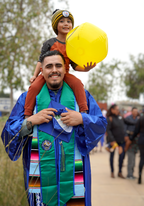 Graduate with child on shoulders