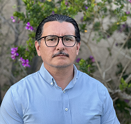 Dark haired male wearing glasses and a dress shirt