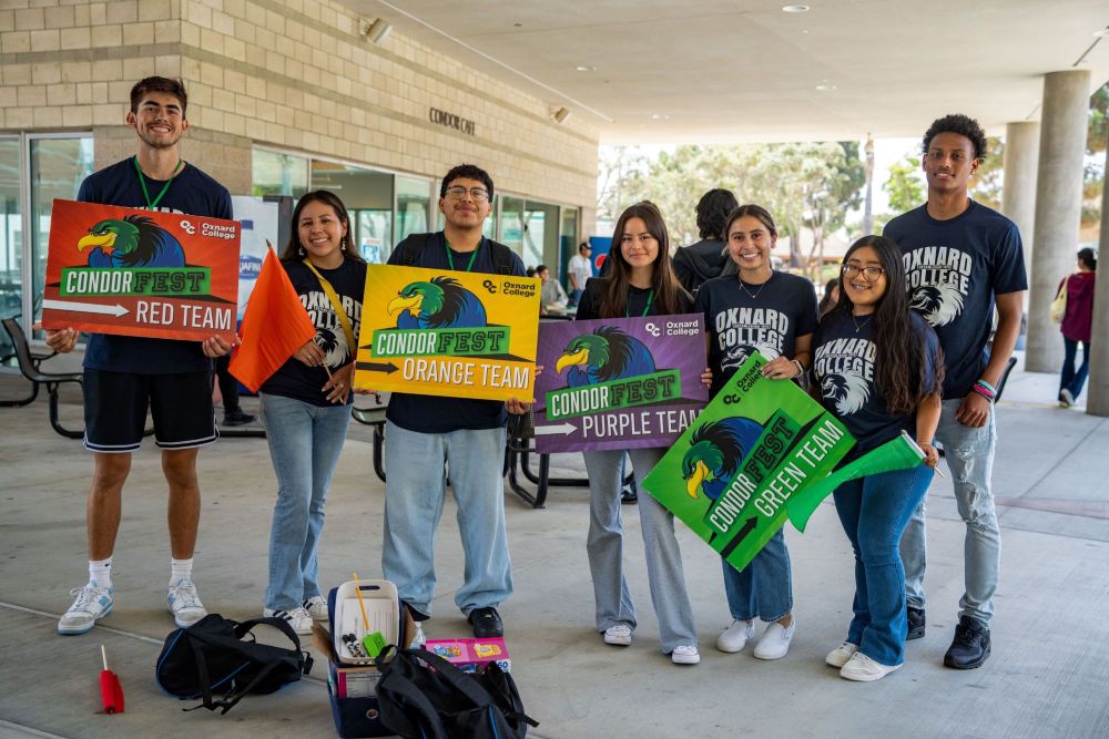 Seven student leads, holding a sign that says, "CondorFest"