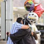 Moorpark College Graduate holding celebratory balloons and h