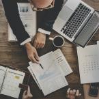 Business workers discussing over graphs on a desk.