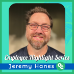 Employee Highlight, Jeremy Hanes, a man with brown hair, glasses, and a beard smiling