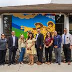 Oxnard College leaders and artists standing in front of new mural on an external wall of Condor Hall.