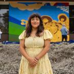 Muralist Elisa Torres poses in front of her mural.