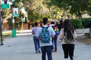group of students with backpacks walking through campus