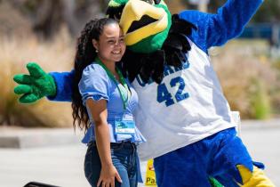 Cory the Condor and a female student posing for the camera