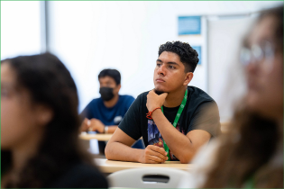 Male student paying attention in class.