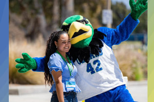 Cory the Condor and a female student posing for the camera