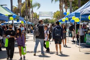 OC Expo Event, students walking around holding a green bag.