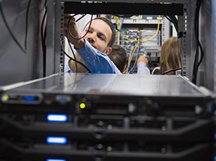 man adjusting computer cables in a computer tower