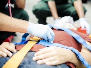 people performing emergency  procedures on someone laying on a stretcher