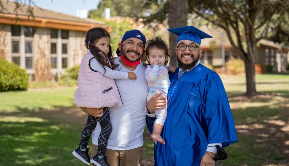 Oxnard College graduate posing with their family members.