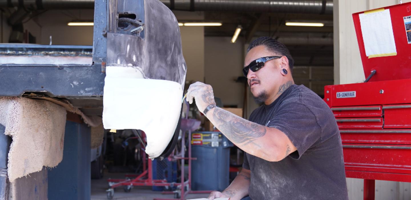 student working on car bumper