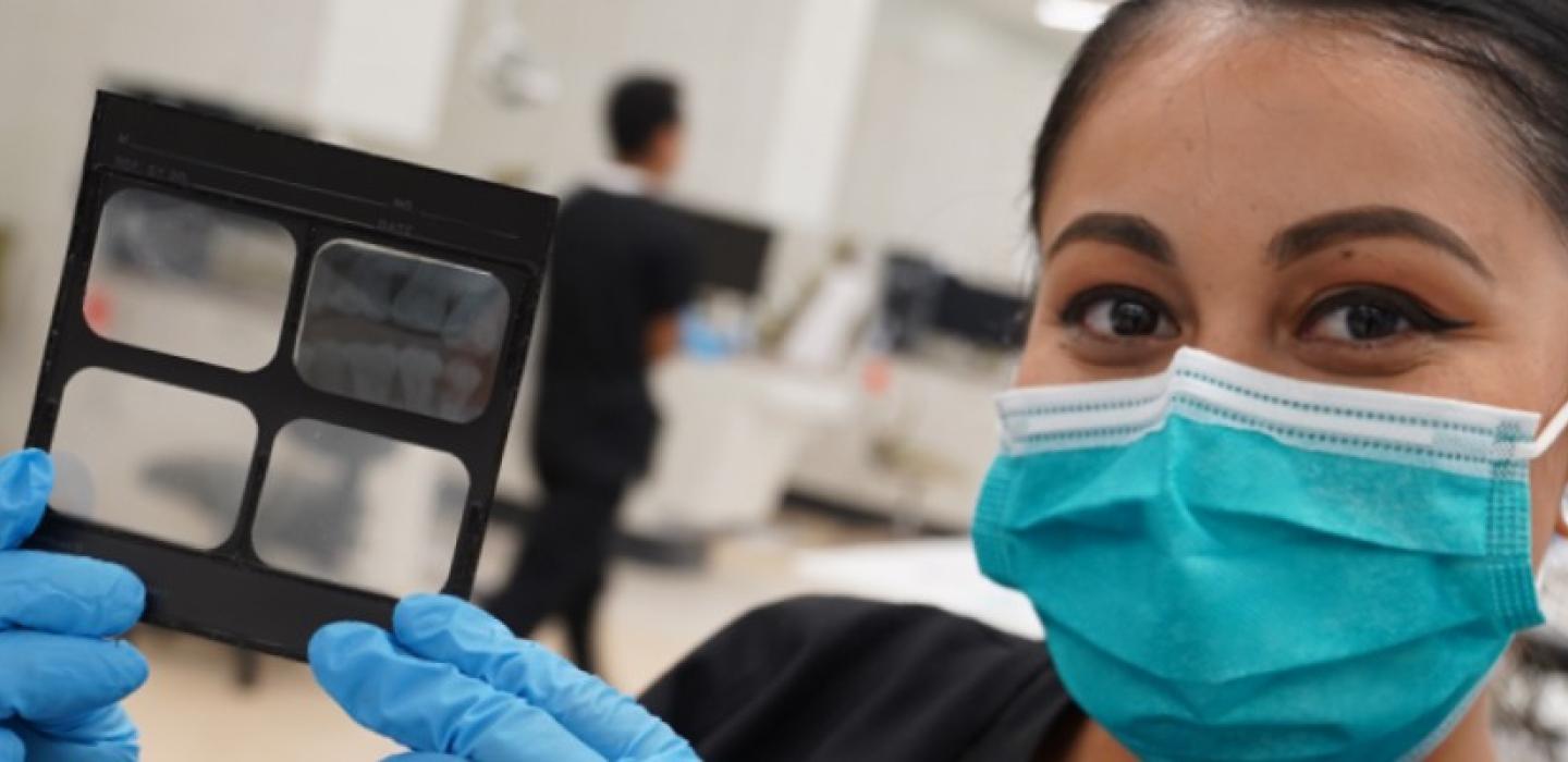 dental student holding xray of mouth