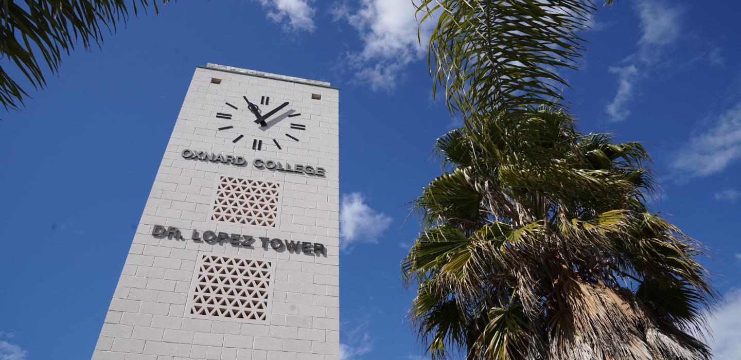 Dr. Lopez clock tower at Oxnard College with palm tree in foreground