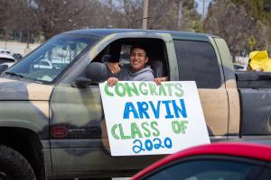 Drive thru graduation at Oxnard College, student holding a s