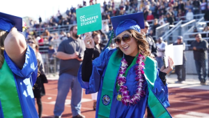 Oxnard College graduate holding a sign that reads: OC Transfer Student