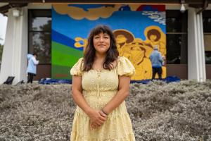 Muralist Elisa Torres poses in front of her mural.